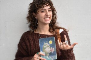 Sasha Wizelman holds up her poetry notebook.