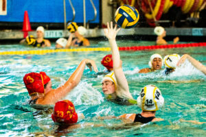 Girls water polo players battle for the ball.