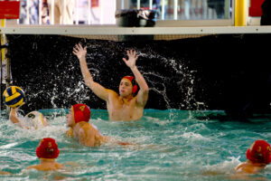 Boys water polo defends against a goal.