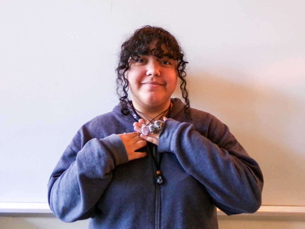 Marisol Marcucci holds up a necklace she made.