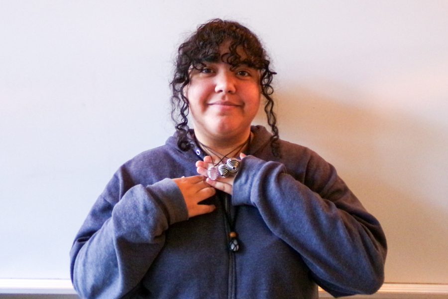 Marisol Marcucci holds up a necklace she made.