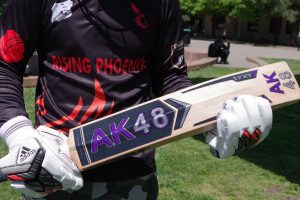 Yasir Zara displays his cricket bat on the Campus Green